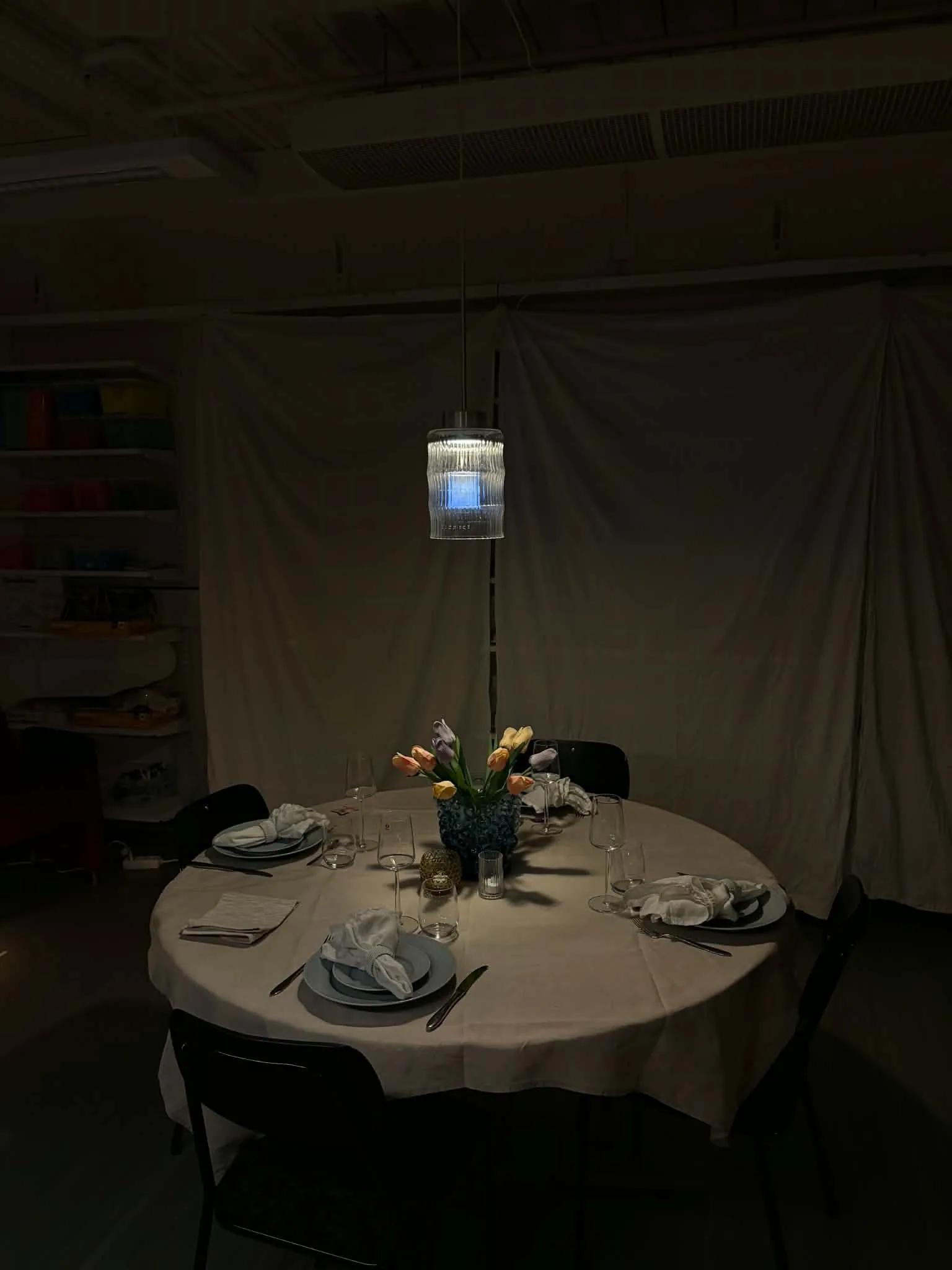 Celina above the table in a darkened room