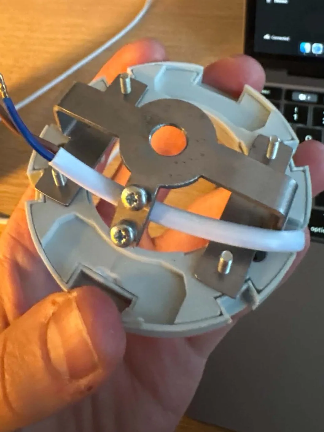 The bent steel bracket with the cable clamped to it
