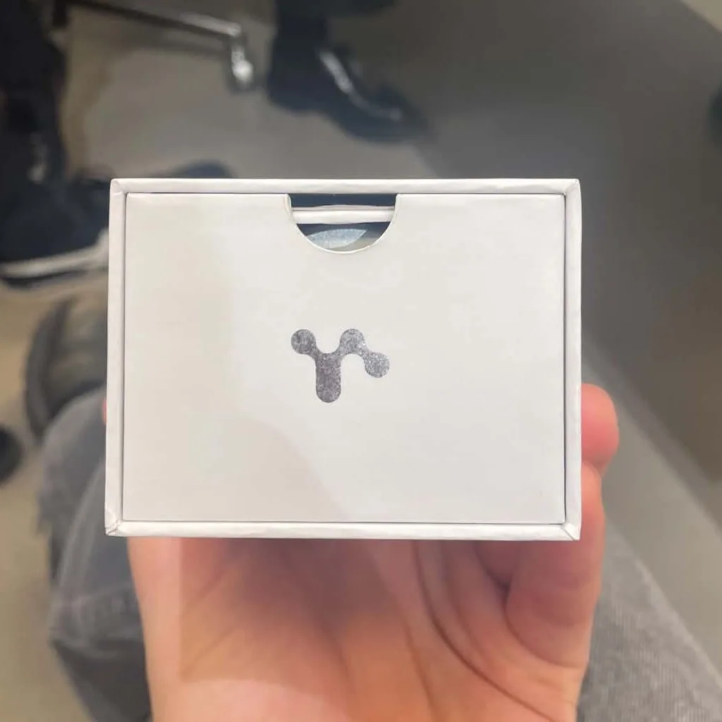 The end of the white box with the symbol in silver and a thumb notch