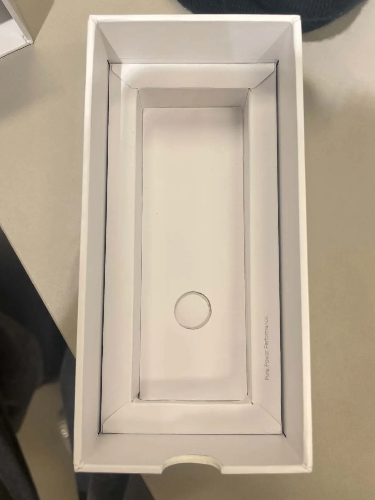 The open box seen from above, with a white inner tray and the line Pure. Power. Performance.