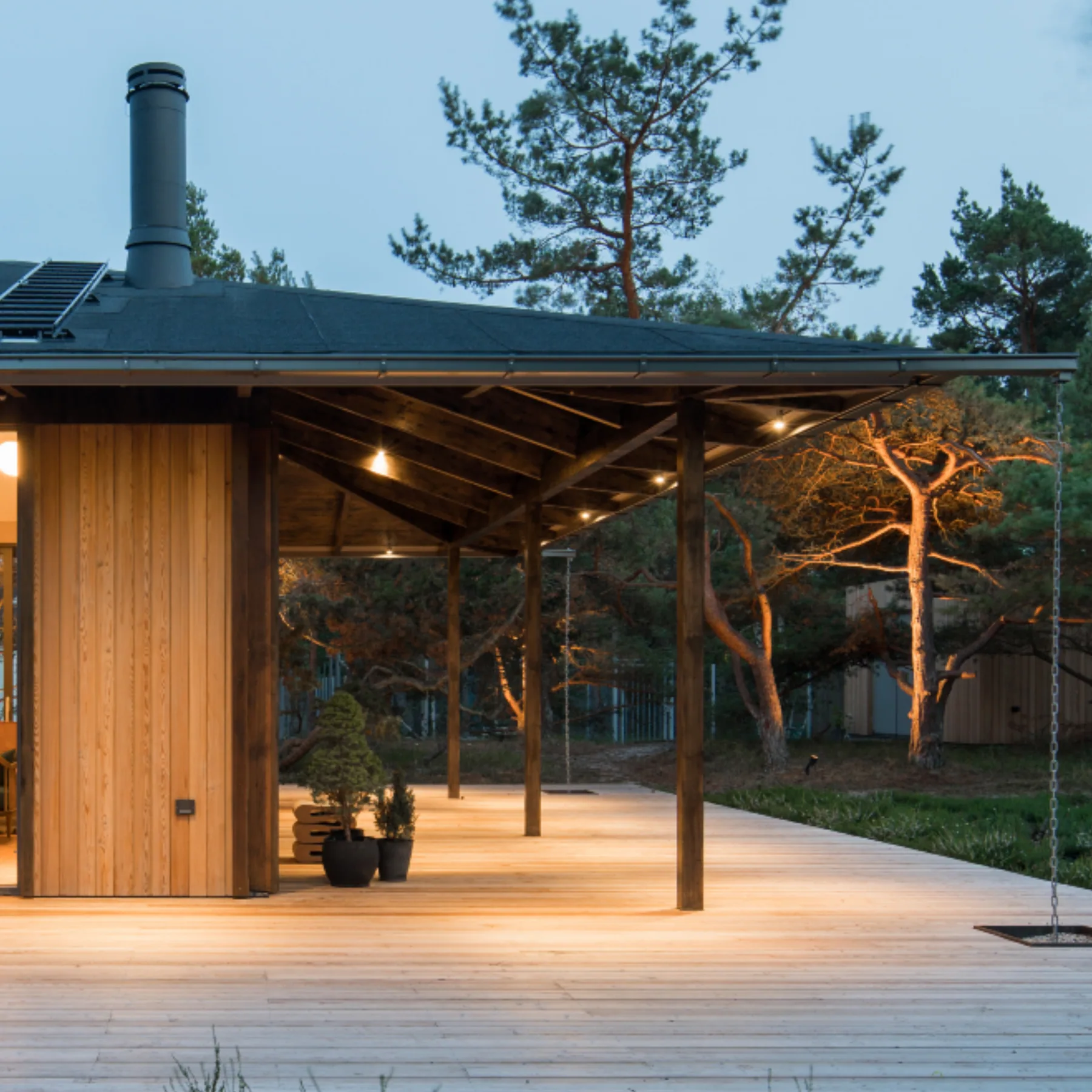 An empty wooden deck in front of a house at dusk